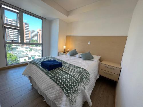 a bedroom with a bed and a large window at Cityhaus apartment zone 10 near hotel area in Guatemala