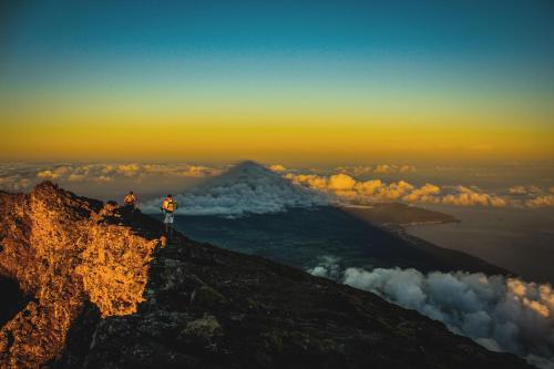 two people standing on the top of a mountain at Engenho Hostel in Lajes do Pico