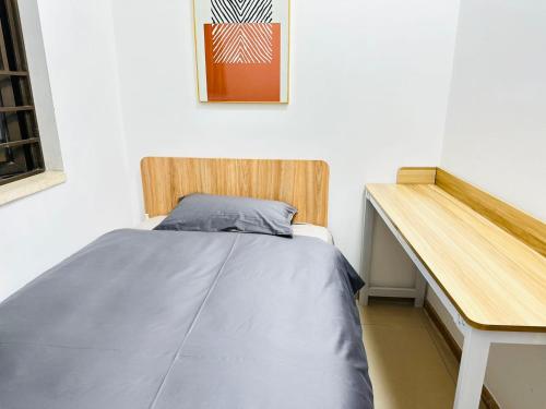uma cama num quarto ao lado de uma secretária em Homeboy享家-轻奢民宿 em Shenzhen