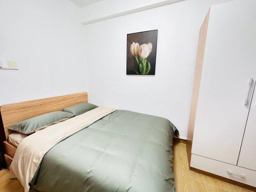 um quarto com uma cama e um quadro de flores em Homeboy享家-轻奢民宿 em Shenzhen