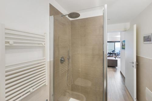 um chuveiro com uma porta de vidro na casa de banho em Appartamento con vista Mare Noli em Noli