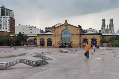 un homme marchant devant un grand bâtiment dans l'établissement Bienvenue à Nancy, à Nancy