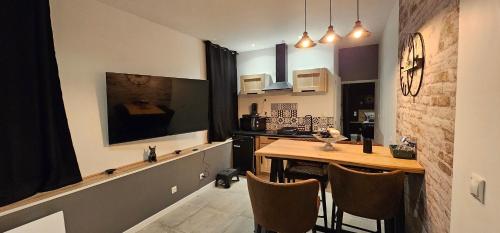 cocina con mesa de madera y cocina con fogones en Le Clos Maldier - Gîte Les Ecureuils, en Laon