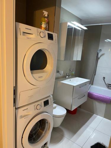 a bathroom with a washing machine and a toilet at Tina in Villeneuve