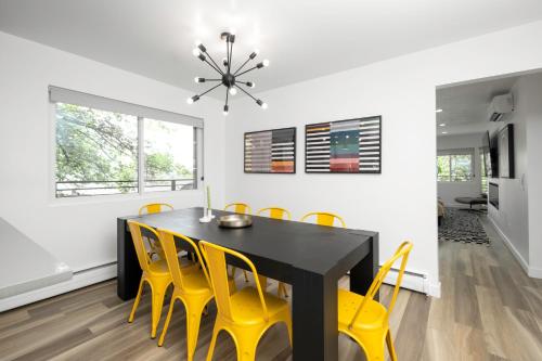 a dining room with a black table and yellow chairs at Renovated 3BD 2BA Escape w Hot Tub and City Views in Salt Lake City
