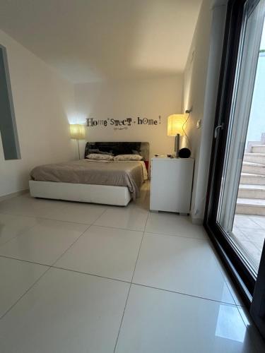 a white bedroom with a bed and a window at SAN NICOLA LUXURY in Bari