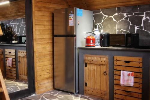 een keuken met een roestvrijstalen koelkast en een magnetron bij Katskhi Cottage, Your Cozy Stay in Katsʼkhi