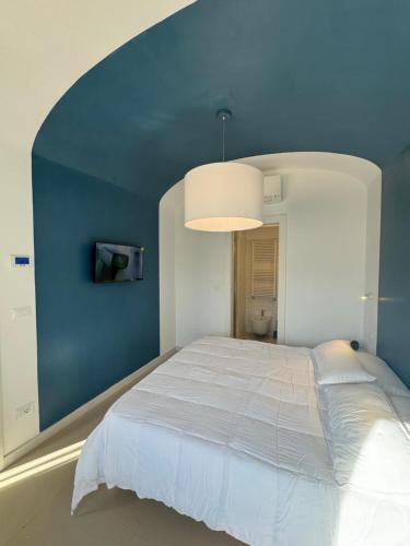 a bedroom with a large bed with a blue wall at Titti guest-house in Finale Ligure