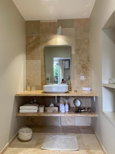 a bathroom with a sink and a mirror at EN VILLE à LA CAMPAGNE 2 in Louhans