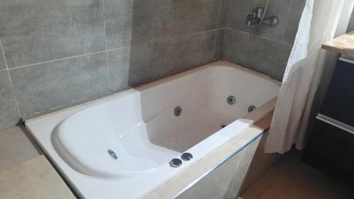 La salle de bains est pourvue d'une baignoire blanche. dans l'établissement Casa amplia con pileta 9 personas, à Luján de Cuyo