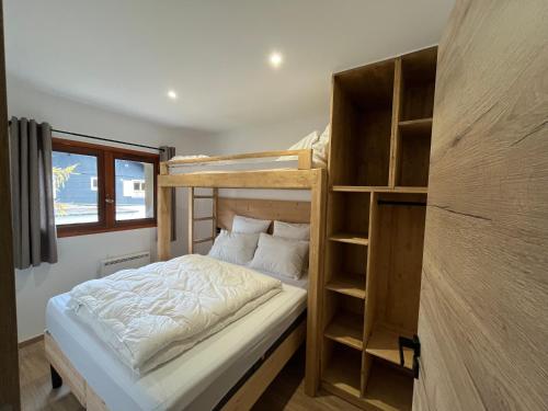 a small bedroom with a bunk bed and shelves at CHALET DE CHARME LE GOLEON - 3 Chambres - VALLOIRE CENTRE in Valloire