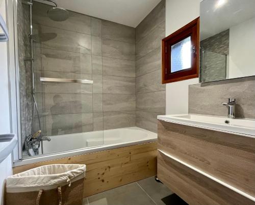 bagno con vasca e lavandino di CHALET DE CHARME LE GOLEON - 3 Chambres - VALLOIRE CENTRE a Valloire