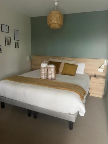 um quarto com uma cama grande e 2 almofadas em Chambre privatisée L’Ermitage vue sur la mayenne em Château-Gontier