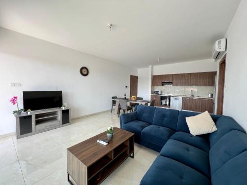 a living room with a blue couch and a table at Kings Boutique Apartment/2BR in Strovolos