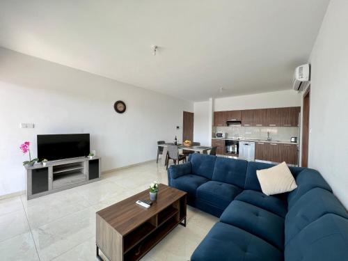 a living room with a blue couch and a kitchen at Kings Boutique Apartment/2BR in Strovolos