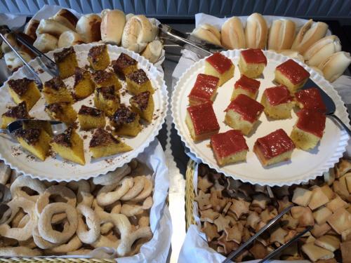 two cakes and pretzels and other food on trays at IT Itabira Hotel in Itabira
