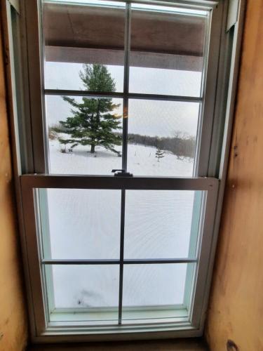 a window with a view of a snow covered field at Auberge Schweizer in Sutton
