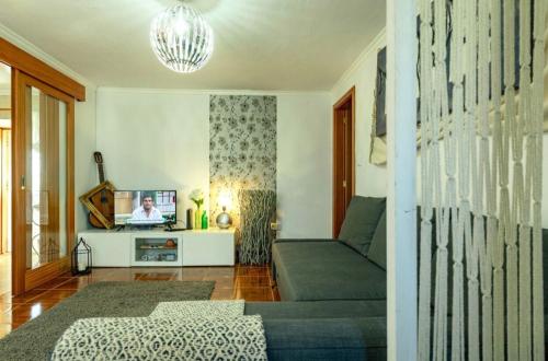 a living room with a couch and a tv at Casa do Miradouro in Santa Bárbara