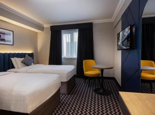 a hotel room with two beds and a table at Academy Plaza Hotel in Dublin