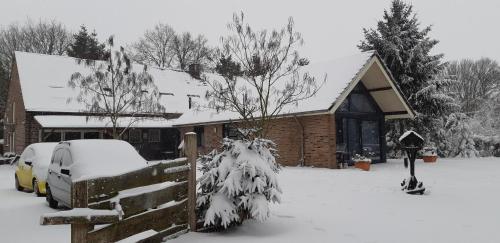 a house with a fence covered in snow at Ottenskamp4 en Het Achterhuis in Siebengewald
