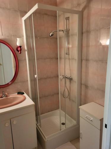 une douche avec une porte vitrée dans une salle de bain dans l'établissement Chambre dans meublé tout équipé, à Angoulême