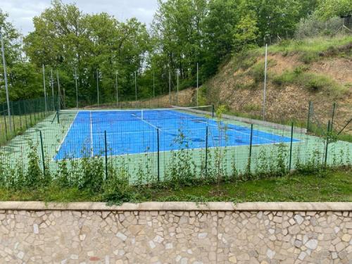 a tennis court behind a chain link fence at Villa Le Cicale - Irpinia in Prata di Principato Ultra
