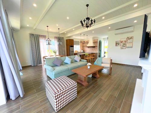 een woonkamer met een bank en een tafel bij Seamoni Seaview Villa 01 - Novaworld Phan Thiết in Phan Thiet
