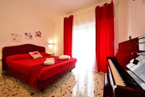 a bedroom with a red bed and a piano at Floral Holiday in Minori
