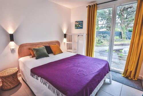 - une chambre avec un lit doté de draps violets et une fenêtre dans l'établissement Villa CHEBEC Appartement en rez de jardin avec terrasse vue sur golf d Hossegor, à Hossegor