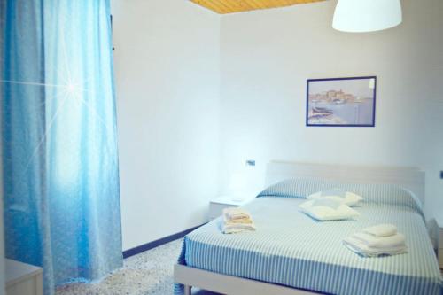 - une chambre avec un lit et des serviettes dans l'établissement CASA SINGOLA ALLE PORTE DEL SINIS, à Baratili San Pietro