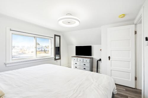 a white bedroom with a bed and a window at Logan's House in Downtown Frederick in Frederick