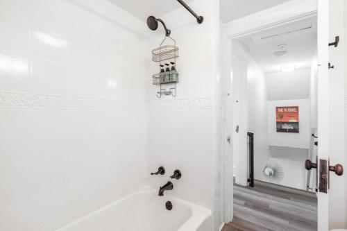 a white bathroom with a tub and a sink at Logan's House in Downtown Frederick in Frederick