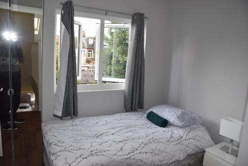 een man die een foto neemt van een bed in een slaapkamer bij Four Bedroom House Chandos Road in Londen