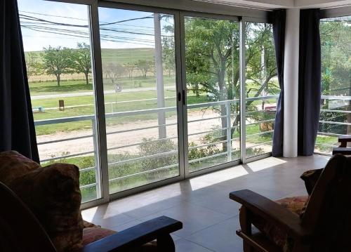 una sala de estar con grandes puertas correderas de cristal en Alfonsina Holiday Home en Sierra de la Ventana