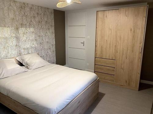 a bedroom with a bed and a wooden door at Maison "La Butte" - Suisse Normande in Ségrie-Fontaine