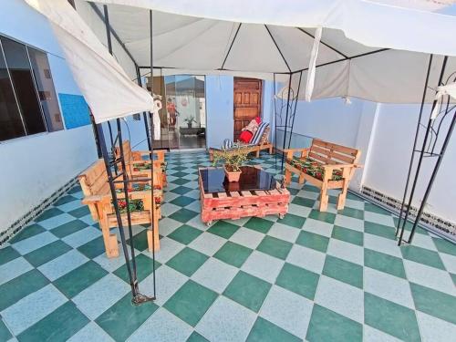 ein Wohnzimmer mit einem Tisch, Stühlen und einem Sonnenschirm in der Unterkunft Equipada, Amplia, 5 min de la Playa in Pacasmayo