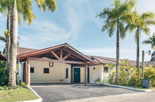 a house with palm trees in the driveway at Villa with 3 bedrooms private pool and ocean view in Santa Bárbara de Samaná