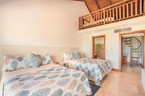 a bedroom with two beds and a staircase at Villa with 3 bedrooms private pool and ocean view in Santa Bárbara de Samaná