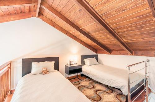 two beds in a room with wooden ceilings at Villa with 3 bedrooms private pool and ocean view in Santa Bárbara de Samaná