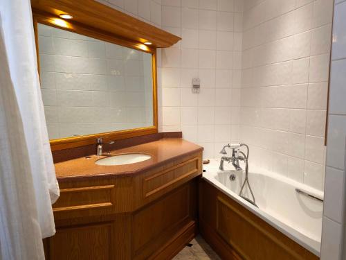 uma casa de banho com um lavatório, uma banheira e um espelho. em Crown Hotel Stone em Stone
