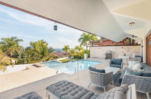 a house with a swimming pool and a patio at Villa with 3 bedrooms private pool and ocean view in Santa Bárbara de Samaná