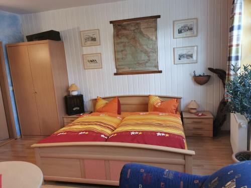 um quarto com uma cama grande e lençóis coloridos em Gästehaus Locanda al Castello Stolpen em Stolpen