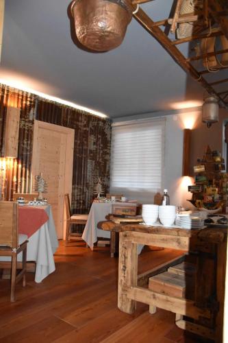 uma sala de jantar com duas mesas com tigelas brancas em B&B Ronco Carbon em Gallio