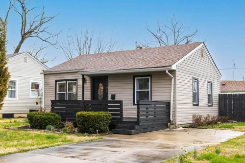 a white house with a black front porch at Bluegrass Bungalow in Louisville