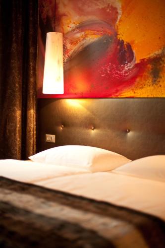 a bedroom with a bed with a headboard and a lamp at Der Wilhelmshof in Vienna