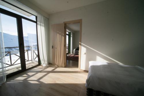 a bedroom with a bed and a large window at Chalet Papa Basili in Gudauri