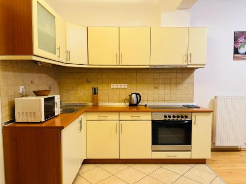 uma cozinha com armários brancos e um micro-ondas em OPERA HOUSE CENTRAL STUDIO for 4 persons em Budapeste