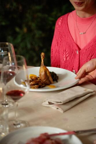 a woman sitting at a table with a plate of food at Agriturismo Podere La Rocca in Abbadia di Montepulciano