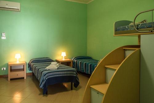 2 camas en una habitación con paredes verdes en Appartamento B - Le Terrazze, en Ribera