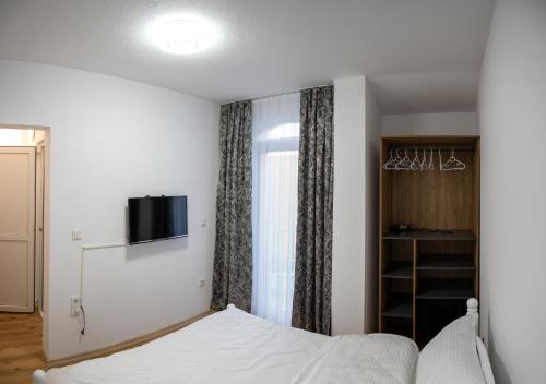 1 dormitorio con 1 cama y TV en la pared en Hotel Lux, en Struga